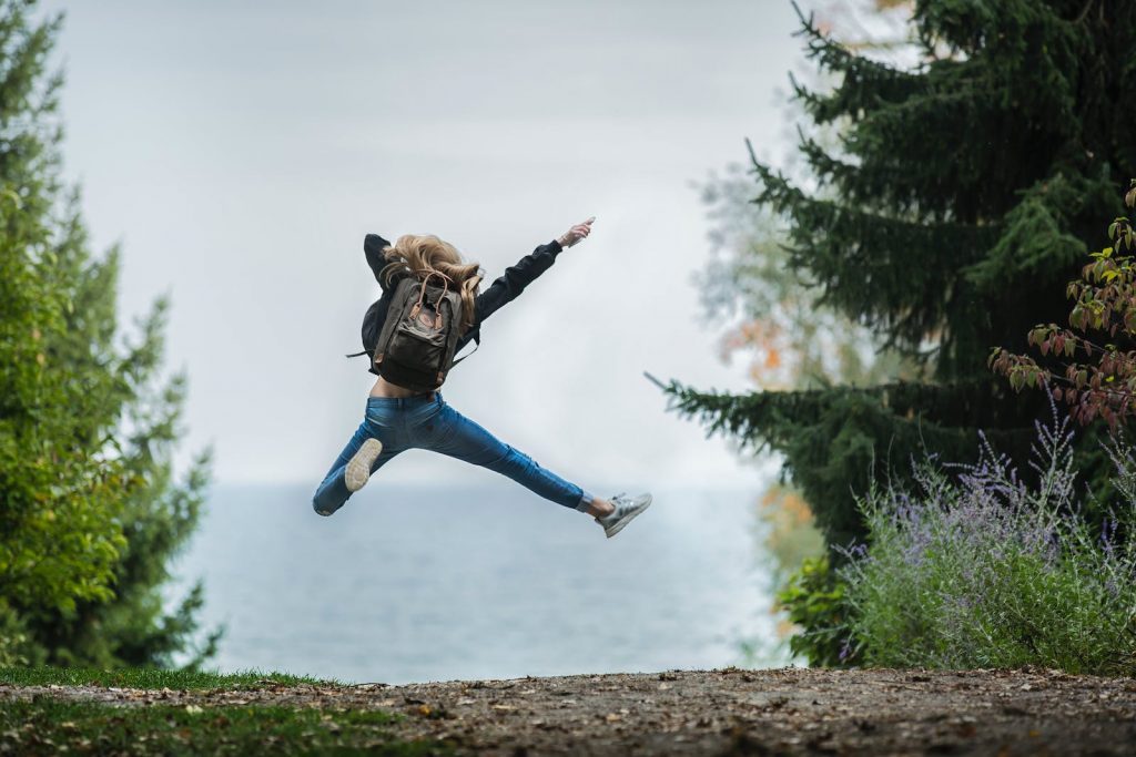 Teenager Jumping Wearing Green Backpack